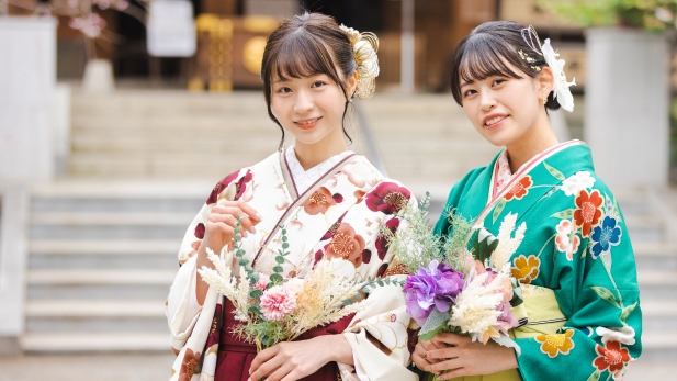 花を手にする袴姿の女学生二人