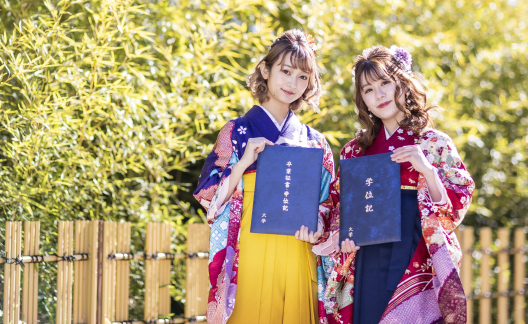 卒業証書を手にしている2人の袴姿の女子学生