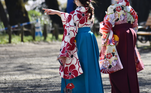 袴姿の女子学生の後ろ姿。前方に指を指している