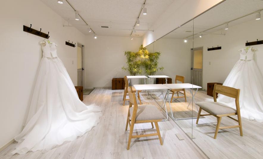 衣装が飾られた白基調のKADODEサロンの明るい店内