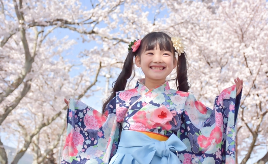 桜の木を前に立つ袴姿の少女