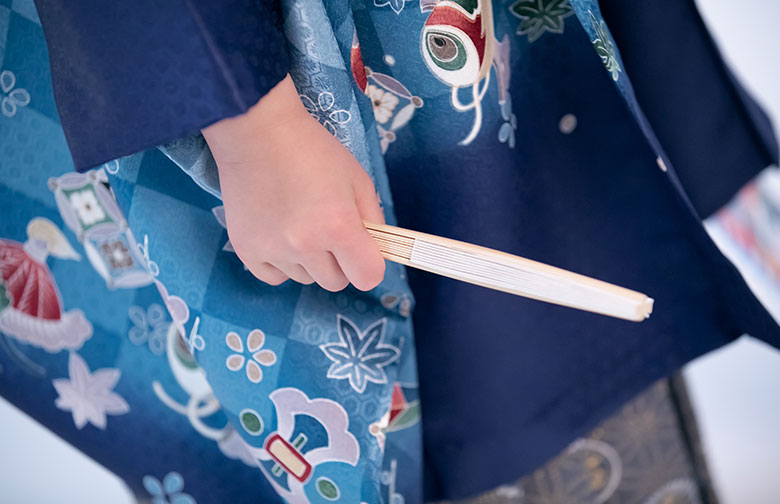 扇子を手にした男の子の手のアップ