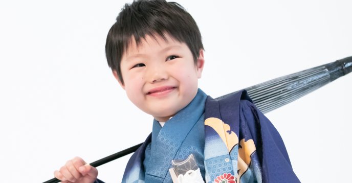 番傘を肩に担ぐ着物姿の男児