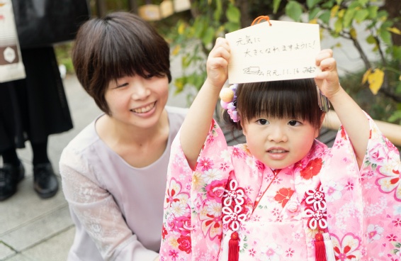 絵馬を掲げる3歳の女の子と母親