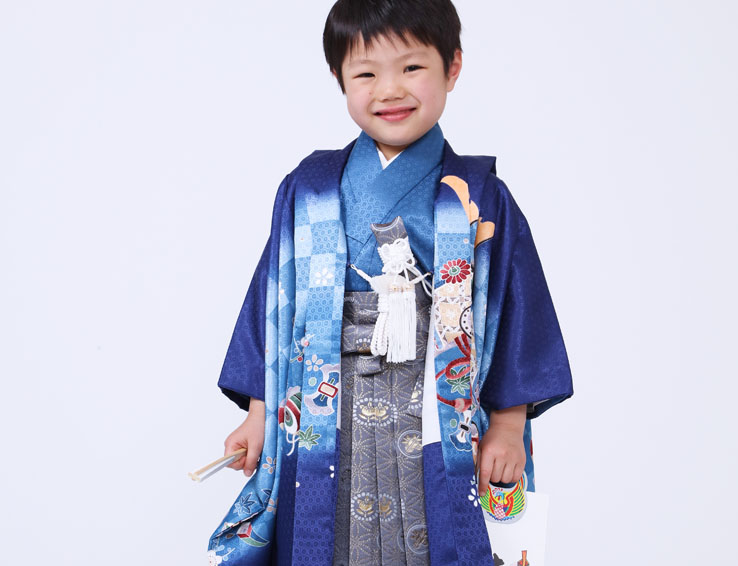 番傘を肩に担ぐ着物姿の男児